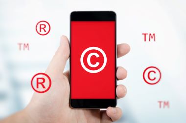 Symbol a photo of copyright, trademark symbols flying around smartphone.