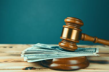 Penalty dollars on judge gavel.